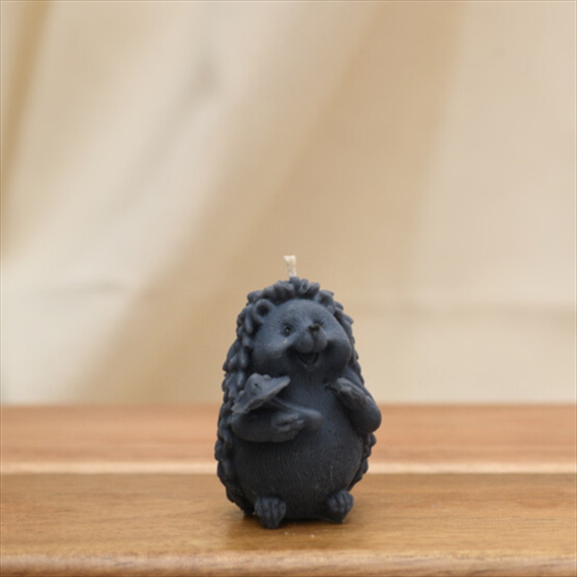 CANSCUANMLHDGMRM.jpg HEDGEHOG HOLDING MUSHROOM CANDLE - Image 1